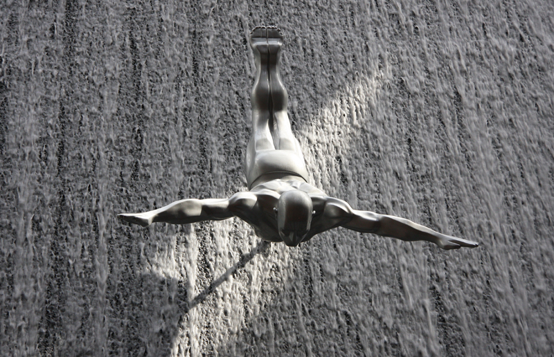 Fiberglas-Skulpturen simulieren am Wasserfall menschliche Springer
