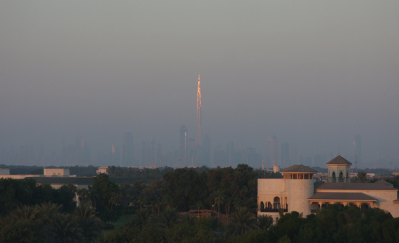 Der weit entfernte Burj Khalifa  im Licht der untergehenden Sonne
